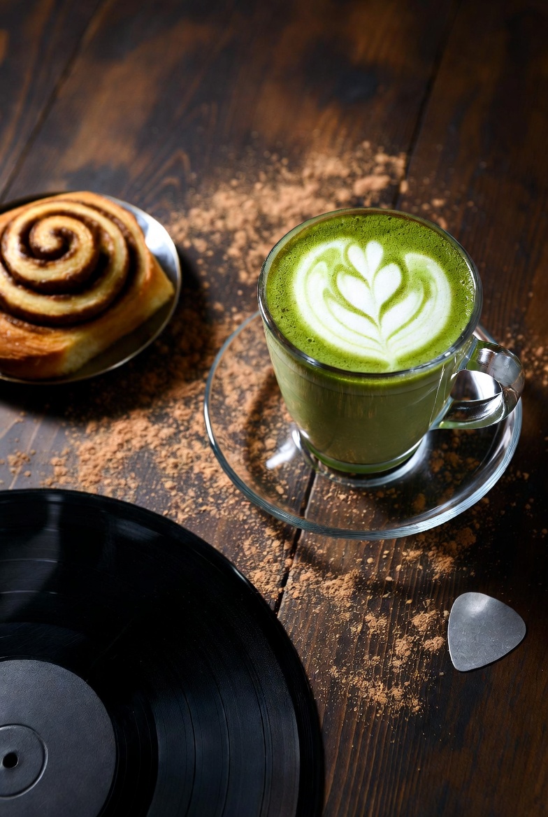 Matcha latte art with cinnamon roll and vinyl record